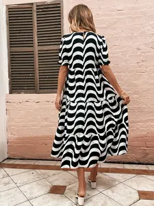 Back view of a black and white wavy print tiered midi dress with stylish bubble sleeves