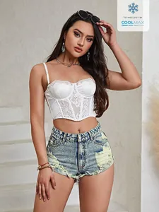 Detailaufnahme der zerrissenen High-Waist-Jeansshorts mit ausgefranstem Saum und Löchern.