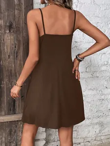 Detailed back view of a solid brown spaghetti strap mini slip dress worn by a model