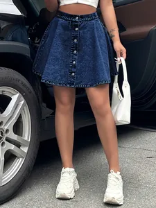 Detailed view of high-waisted acid wash denim skirt styled with white fashion sneakers
