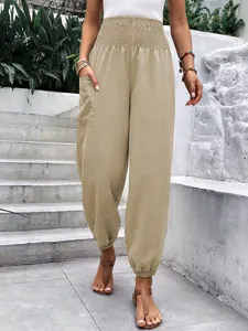 Détail de ce pantalon taille haute froncé avec poches et chevilles élastiquées