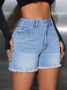 Detail view of high waisted denim shorts with raw fringe hem and light blue wash