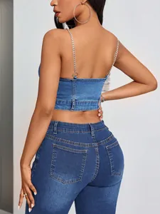 Achteraanzicht van een blauwe denim crop top met zilveren kettingbandjes en open rugpand