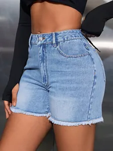 Close-up detail of high-waist denim shorts with frayed hems and a light blue wash