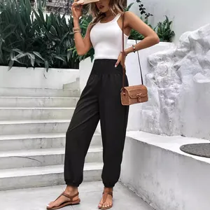 Pantalon de jogging noir taille haute pour femme avec taille smokée et ourlet élastique.