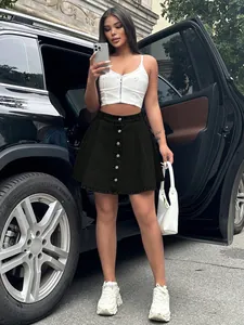 Street style shot of a high-waisted black denim A-line button-up mini skirt on model