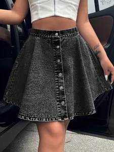 Close-up of high-waisted acid wash denim A-line skirt with silver button-front detailing.