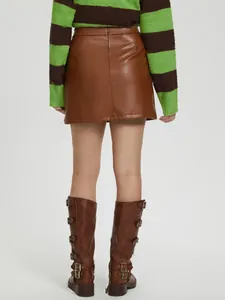Vue arrière d'une mini-jupe trapèze en cuir PU marron avec des bottes montantes à boucles