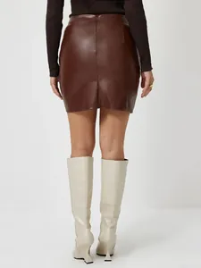 Vue arrière détaillée d'une mini-jupe trapèze en cuir PU marron avec une coupe ajustée chic.