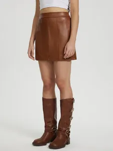 Vue détaillée d'une mini-jupe trapèze en similicuir marron avec coutures verticales.