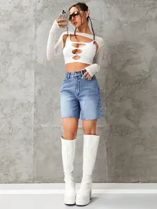 Modische High-Waist-Denim-Shorts mit Fransen, kombiniert mit einem weißen Crop-Top und Stiefeln