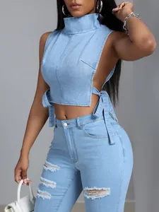 Dettaglio di un crop top in denim azzurro sexy con lacci laterali e collo alto