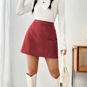 Élégante mini-jupe trapèze en similicuir rouge foncé avec haut en tricot blanc et bottes
