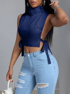 Vista dettagliata di un sexy crop top in denim blu navy con collo alto e lacci laterali.