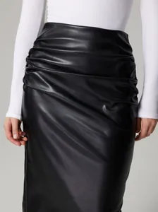 Détail d'une jupe crayon en similicuir noir avec d'élégants froncements latéraux.