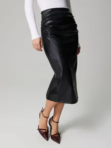Détail d'une jupe midi en PU à taille haute froncée avec une silhouette moulante élégante