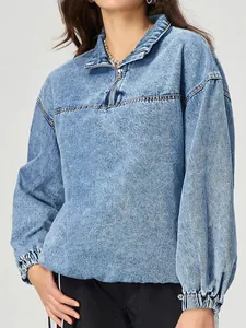 Dettaglio di pullover in denim ampio con mezza zip e texture lavata
