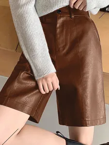 Detail of brown PU leather wide-leg shorts showing fine stitching and smooth premium texture.