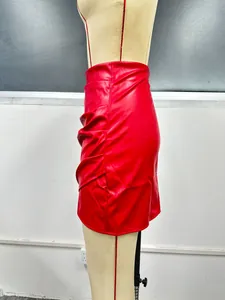 Détail latéral d'une mini-jupe en cuir PU rouge avec des plis froncés sur le côté
