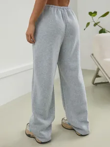 Vue arrière d'un pantalon de jogging large gris pour femme dans une pièce épurée