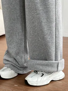Gros plan détaillé d'un pantalon de jogging gris à jambes larges en tissu doux et ample