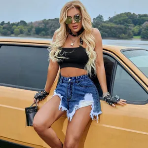 Short en jean taille haute déchiré et effiloché porté par un mannequin près d'une voiture jaune
