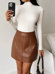 Detail of a brown PU leather mini skirt featuring A-line silhouette and decorative seam stitching