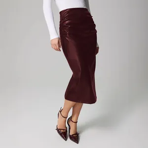 Gros plan sur une jupe midi en cuir PU bordeaux froncée à taille haute et coupe chic