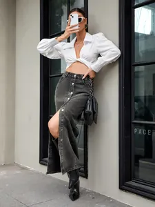 Detail van een retro denim maxirok met een knoopsluiting vooraan en split