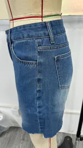 Seitenansicht einer High-Waist-Jeans-Shorts in Blau mit ausgefranstem Saum an einer Puppe.