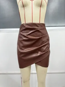 Détail d'une jupe courte élégante en cuir PU marron avec fronces et ourlet asymétrique