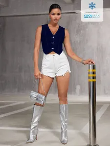 Vue en pied d'un mannequin portant un gilet en jean bleu marine et un short en jean blanc.