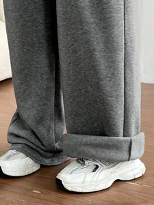 Gros plan d'un pantalon de survêtement gris à jambes larges avec ourlet retroussé