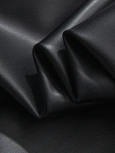 Macro shot of premium black PU leather texture with fine pebbled grain and natural folds.