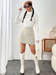 Mini-jupe trapèze chic en similicuir beige à taille haute, tenue complète de mode.