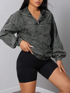 Vista dettagliata di un pullover in denim grigio acid-wash con colletto a cerniera