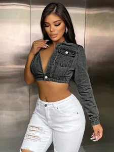 Close-up detail of grey asymmetrical cropped denim top featuring long sleeve and deep V-neck