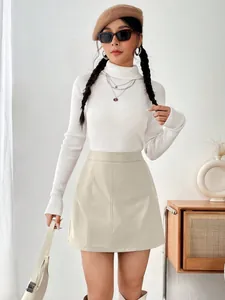 Détail d'une mini-jupe trapèze élégante en cuir PU beige à taille haute sur un mannequin.