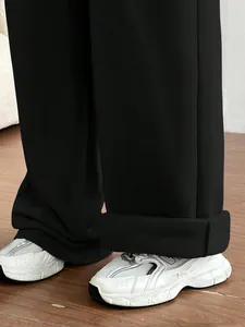 Détail en gros plan d'un pantalon de jogging noir ample avec des baskets blanches massives