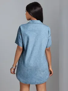 Detailed back view of a light wash short-sleeve denim shirt featuring a curved hemline