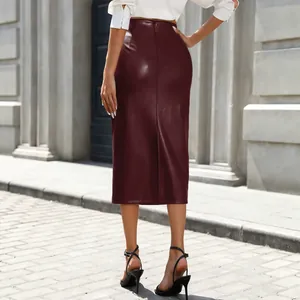 Jupe mi-longue en similicuir bordeaux à taille haute avec fente arrière élégante.