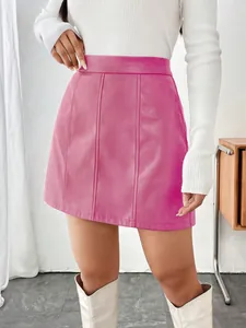 Détail d'une mini-jupe trapèze en similicuir rose vif avec des coutures verticales
