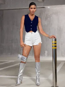 Gilet en jean bleu foncé col en V avec short blanc dans un garage industriel