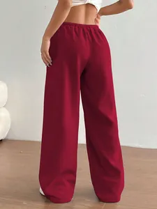 Vue de dos d'une femme portant un pantalon de jogging large rouge ample et fluide