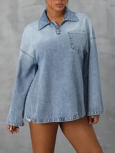 Detail shot of oversized long-sleeve denim shirt with half-zip collar design.