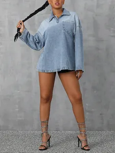 Detailed view of an oversized long-sleeve light blue denim shirt with a half-zip collar.