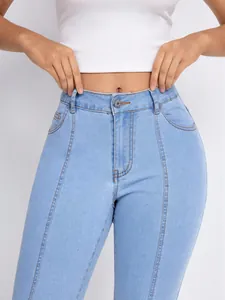 Detail showing light blue high-waisted skinny jeans with vertical seam decorative lines