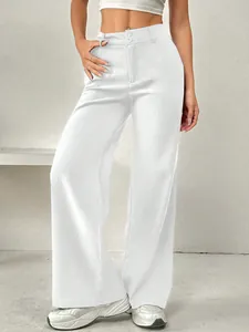 Détail du pantalon blanc à jambe large et taille haute avec double boutonnage.