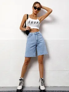 Detail view of women's loose casual washed blue denim bermuda shorts with raw hem