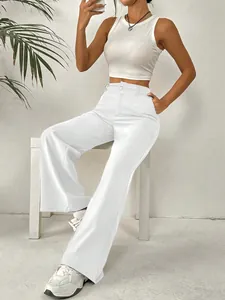 Détail du pantalon large blanc taille haute d'été sur un mannequin dans un décor épuré